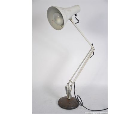 A retro 20th century Herbert Terry Anglepoise Lighting Ltd desk lamp in white raised on a circular cast black base. Measure: 