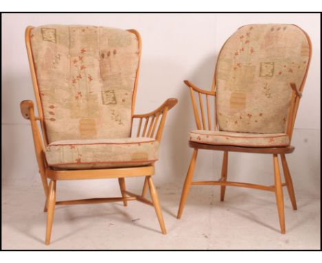 An Ercol beech and elm wood windsor armchair of hoop back raised on saddle seat with crinoline stretchers together with anoth