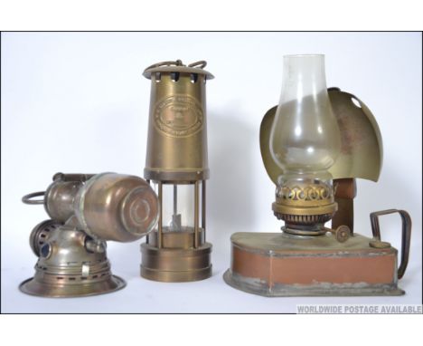 A collection of vintage lamps to include a E. Thomas Williams brass miners lamp, a vintage bicycle acetylene lamp and a brass