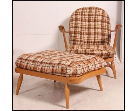 A Ercol Windsor pattern 1970's armchair and ottoman footstool in  beech and elm. The armchair and footrest retaining the orig