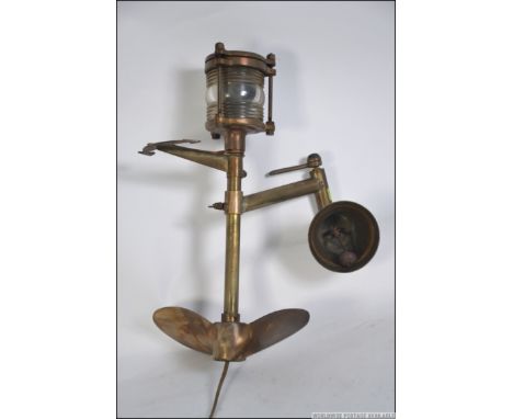 A fantastic 20th century upcycled nautical inspired outside lamp being constructed from a brass ships lamp, brass rudder plea