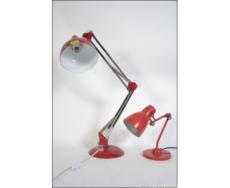 A contemporary 20th century anglepoise style desk  lamp having a red pendant shade raised on a circular base along with anoth