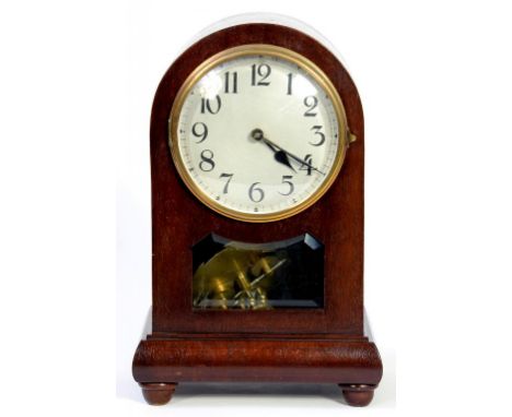 A MAHOGANY MANTEL TIMEPIECE, THE ARCHED CASE WITH BEVELLED GLASS LIGHT CONTAINING BRASS ROTATING PENDULUM, 30CM H, EARLY 20TH