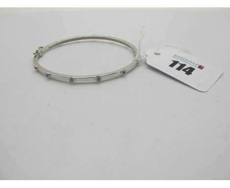 A Modern 9ct White Gold Bangle, with rub over set highlights (one missing), to snap clasp.