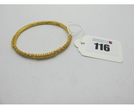 An Indian High Carat Child's Bangle, allover textured detail, and inset highlights, stamped "22K" (10 grams).