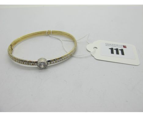 A Fancy Two Colour Bangle, with collet set centre to snap clasp, stamped "385" (7.5 grams).