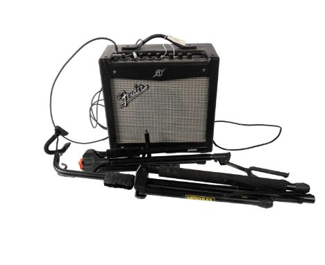 A Fender Mustang I practice guitar amplifier with lead; and two guitar stands.