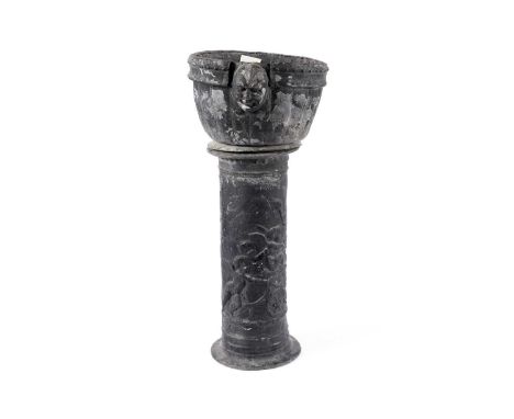 A Georgian lead planter and pedestal base, the planter decorated with a mask and frieze, the plant stand decorated with relie