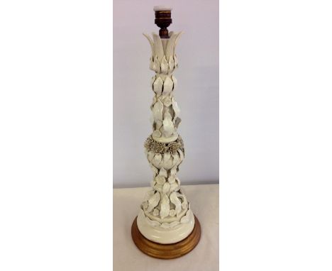 A tall antique continental majolica table lamp in white glaze approx 63cm tall. Slight damage to central flower heads.