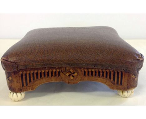 Antique brown leather footstool with wooden frame with Tunbridge ware decoration and ceramic feet.