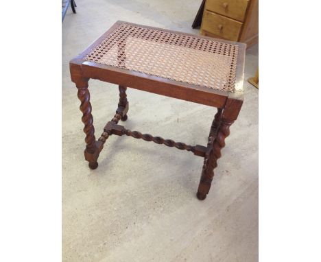 An antique oak rattan topped stool with barley twist legs.