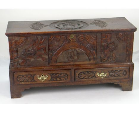 AN INTERESTING 19TH CENTURY WELSH OAK CARVED COFFER CHEST on bracket feet with two base drawers and carved with three front p