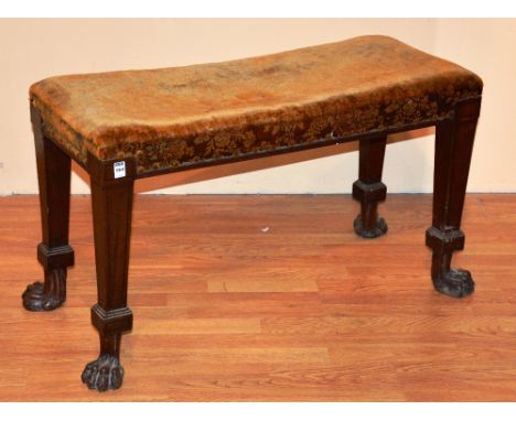 A 19th century mahogany window seat, possibly of Irish origin, raised on hairy paw feet, 52cm high x 93cm wide x 40cm deep