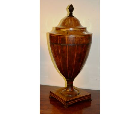 A George III mahogany inlaid urn shaped knife box, the extending lid with turned finial enclosing fitted interior, raised on 