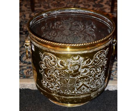 An early 20th century brass embossed planter, decorated with lion mask handles, 41cm high x 40cm wide