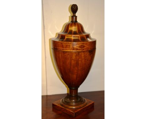 A George III mahogany inlaid urn shaped knife box, the detachable lid decorated with pineapple finial, enclosing fitted inter