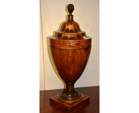 A George III mahogany inlaid urn shaped knife box, the detachable lid decorated with pineapple finial, enclosing fitted inter