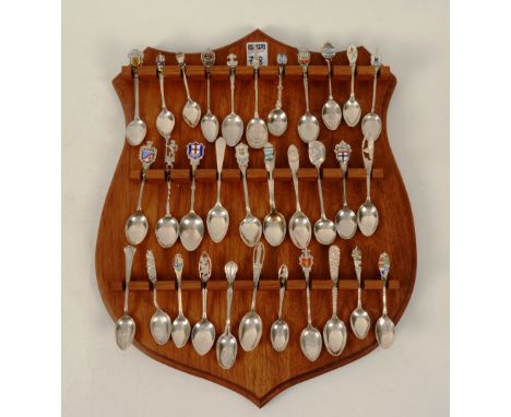 A collection of silver and enamel souvenir spoons, stamped Sterling, 9toz, with modern stand