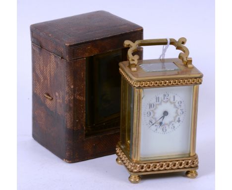 A brass carriage clock, with cream enamel dial, in tooled leather case, 17cm high