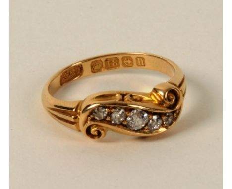 An Edwardian 18ct gold and five stone diamond ring, with five graduated brilliant cut diamonds set in scroll setting, approx 