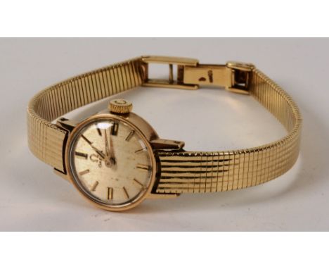A gold lady's Omega wristwatch, with 14ct gold strap and 9ct gold case, the gold coloured dial with baton numerals, inscribed