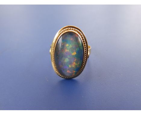 An oval opal coloured ring in '750' yellow metal – 'C969'. Finger size L.