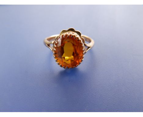 An oval citrine solitaire ring in '9ct' yellow metal, finger size K+.