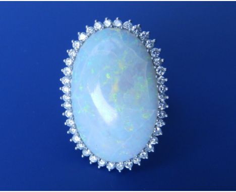 A large modern oval opal & diamond cluster ring in 18ct white gold – the opal 32mm across – with hairline cracks. Finger size