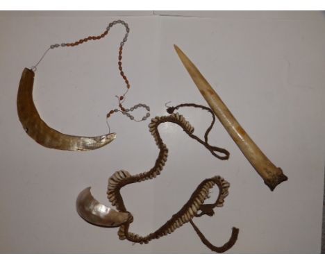 A New Guinea shell pendant, one other and a bone dagger.