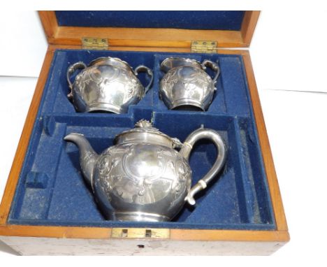 A three piece bachelor's silver tea service in fitted wooden box – FB, London 1869.