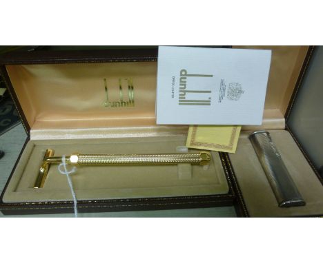 A Dunhill gilded steel presentation tobacco crusher  boxed; and a Dunhill engine turned, steel cased, oval tower design, gas 