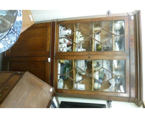 A late 19thC oak standing corner cupboard, having a straight cornice, over a pair of astragal glazed doors, enclosing a shelv