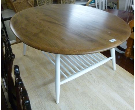 An Ercol elm coffee table, the oval top raised on a white painted underframe, united by a spindled undershelf, raised on turn
