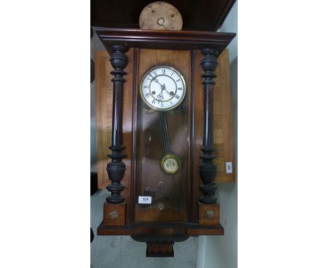 An early 20thC walnut cased Vienna clock with traditionally turned and carved ornament; the gong strike movement faced by a w