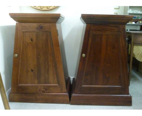 A pair of modern mahogany finished pedestal cupboards, each having a shelf top, over tapered sides and a full height door, on