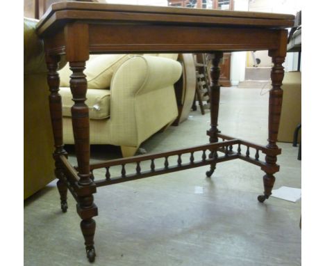 A late Victorian walnut card table, having a foldover top, enclosing a tooled green hide scriber, raised on turned legs with 