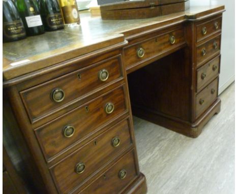 A late 19thC mahogany inverted breakfront desk, having a tooled and gilded green hide scriber, over a central drawer, flanked