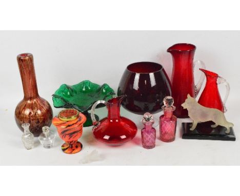 A collection of decorative glass, to include three ruby glass jugs of various forms, two clear and ruby tinted cut glass scen