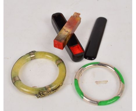 A green hardstone bangle with applied metal dragon and phoenix decoration, also a bright green jadeite snap bangle with white