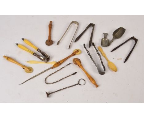 A selection of kitchenalia including four treen pastry wheels, three pairs of 18th century sugar tongs, two bone spoons, a ca