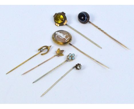 A collection of seven mainly Edwardian stick pins including a 9ct yellow and rose gold maple leaf example, a 9ct yellow gold 