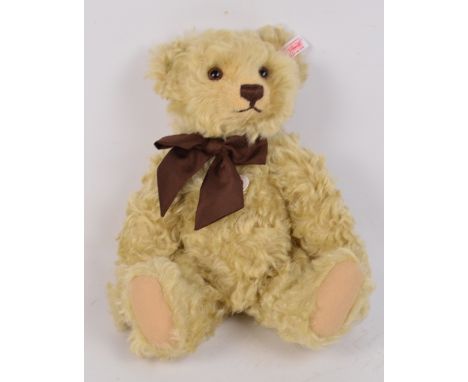 A boxed British Collectors' 2010 Steiff teddy bear no.663291, with numbered white and red tag to ear, with light blonde curly