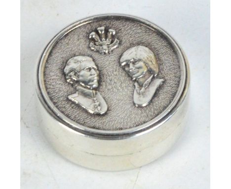 A modern hallmarked silver circular pillbox with portrait busts of Prince Charles and Diana Spencer with the Prince of Wales 