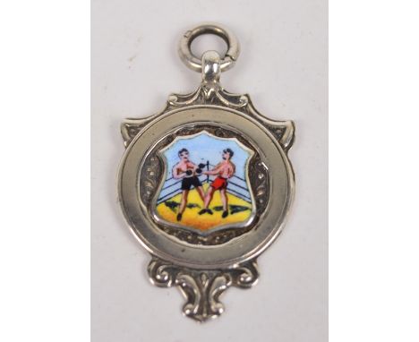 A George V hallmarked silver boxing fob with shield shaped enamel cartouche of two boxers in a ring surrounded by a circular 