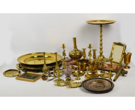 A large quantity of metalware including several circular brass chargers, a copper rectangular tray, Eastern vases, a beer tap