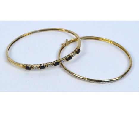A narrow 9ct yellow gold snap bangle set with five oval blue spinel stones alternating with diamond chips on pierced gallery 