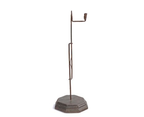                         A floor standing ironrush light and candle holder, the jaws and candleholder above a sprung adjusting