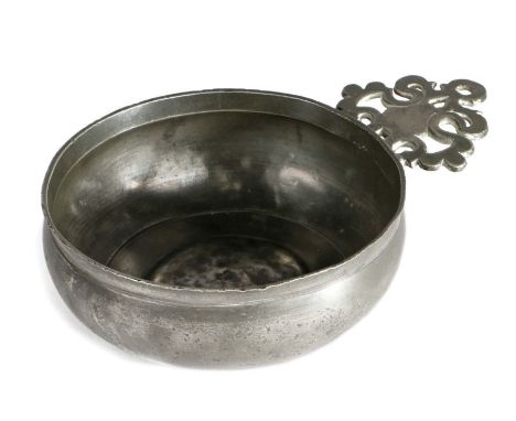 A pewter porringer, English, circa 1700The single ear with triangular bracket, bellied bowl with bossed base, maker’s mark of