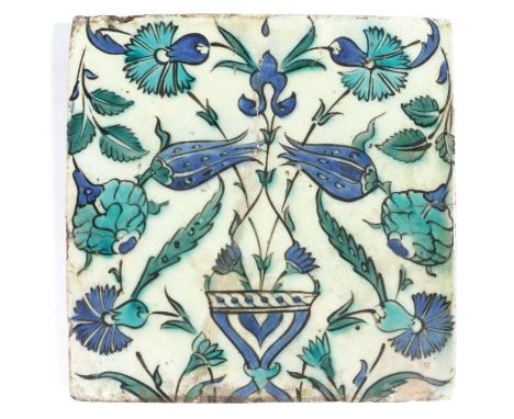                         A 17th century Iznik tile, designed with a flower -filled vase, in blues, blacks and turquoise, resto