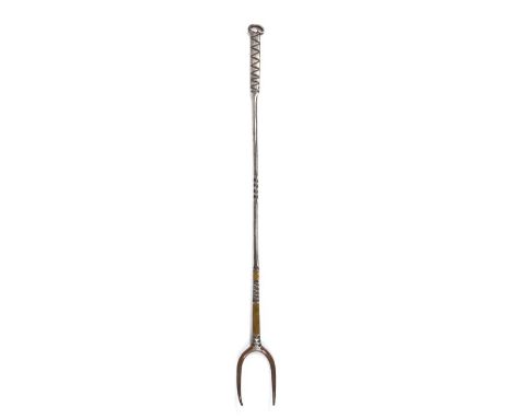 An iron and brass-inlaid meat fork, circa 1800, with two curving tines, the long stem with ‘chip’ and chamfered edges, centre